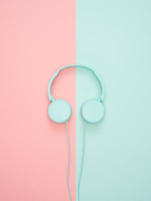 Minimalist headphones on a pink and mint background, artistic and modern.